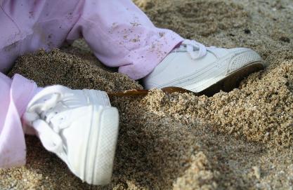 Feet in the sand.  She scooped up sand with a piece of seaweek and dumped it on her leg.  She's such a smart girl!